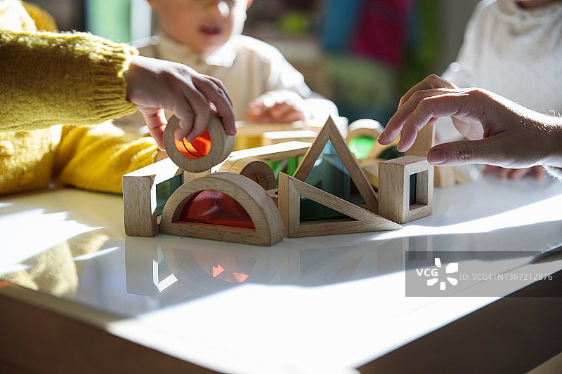 小朋友在桌子上玩彩色积木图片素材