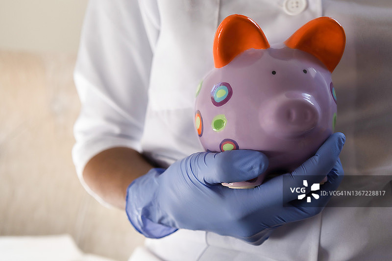 医护人员拿着色彩鲜艳的储蓄罐图片素材