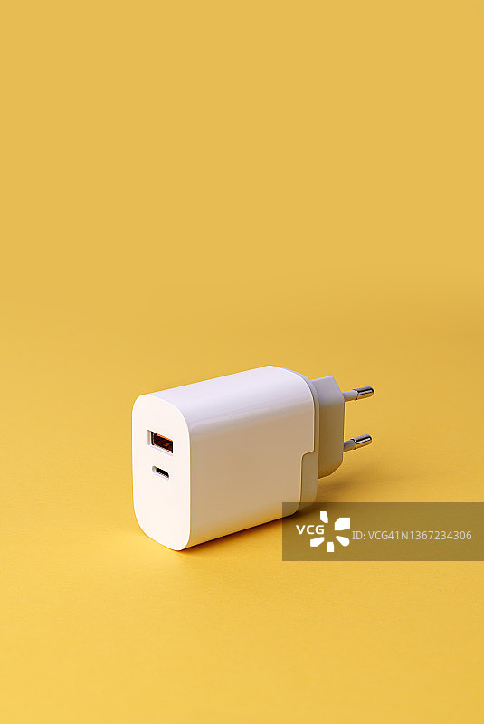 黄色背景下的智能手机USB充电器图片素材