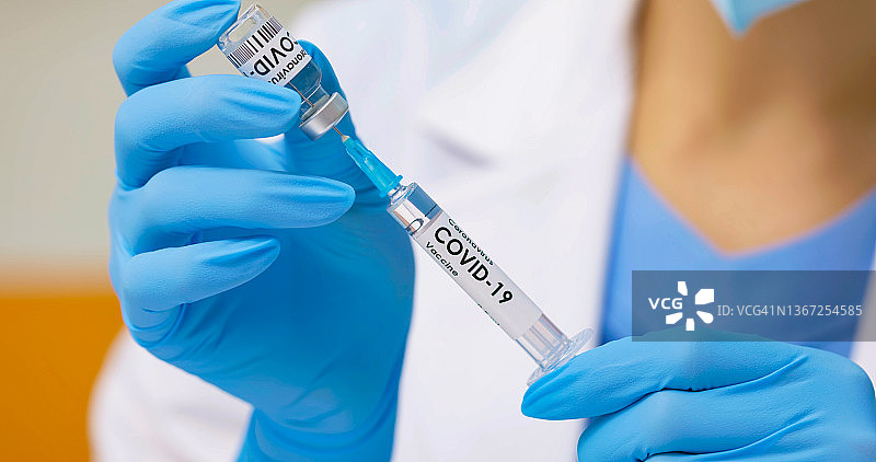 医生将疫苗抽取到注射器中图片素材