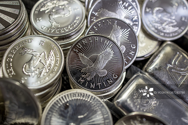 堆叠的银币和银条，聚焦阳光铸币厂1盎司银币图片素材