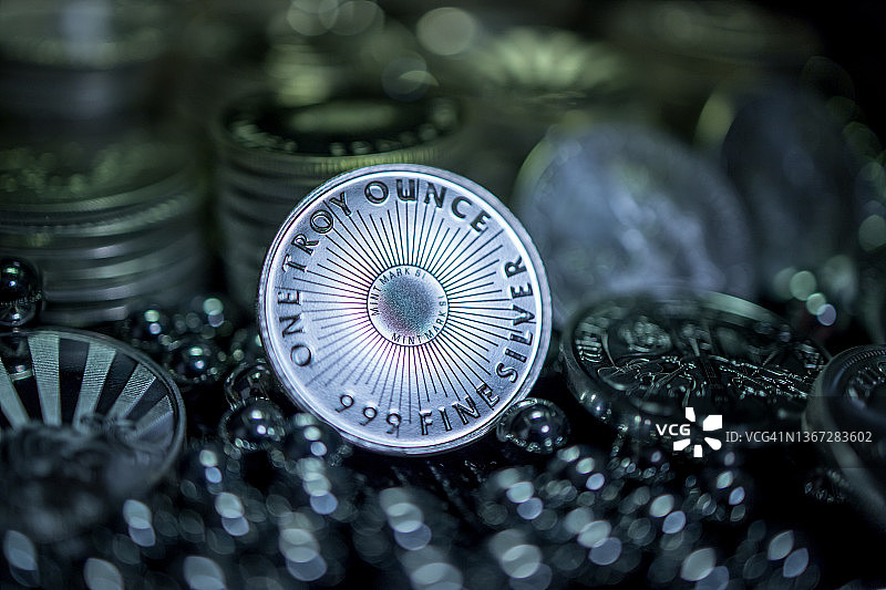 一金衡盎司银币靠在银币堆上，周围环绕着银球轴承图片素材