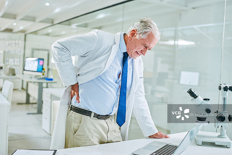 老年科学家在实验室工作时感到背痛图片素材