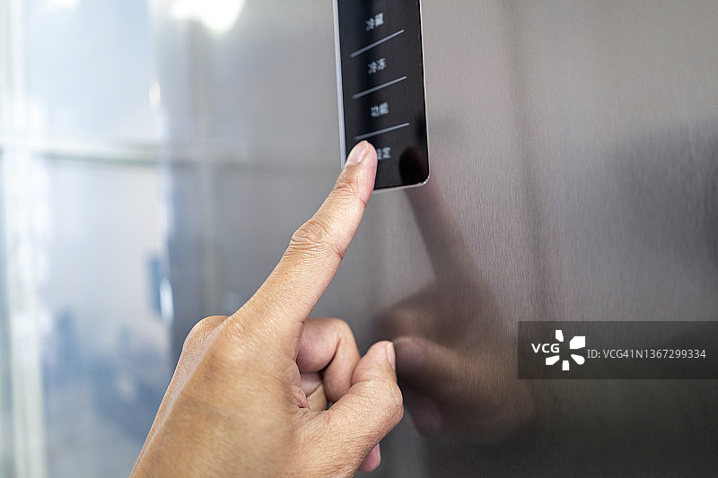 触摸冰箱按钮的手图片素材