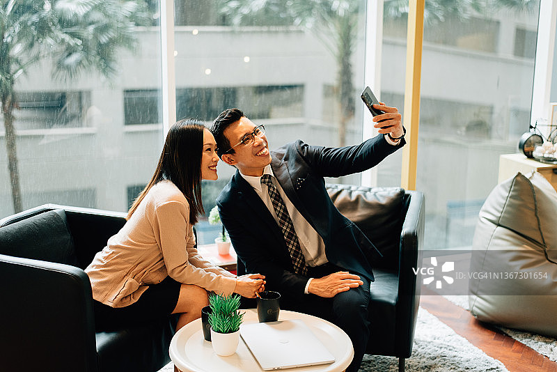 两个快乐的现代亚洲商务人士自画像图片素材