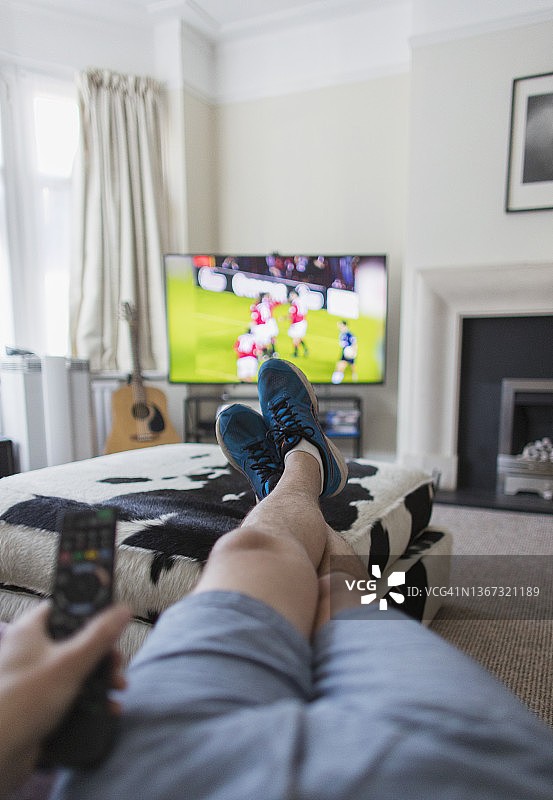 男子在客厅看电视上的足球比赛图片素材