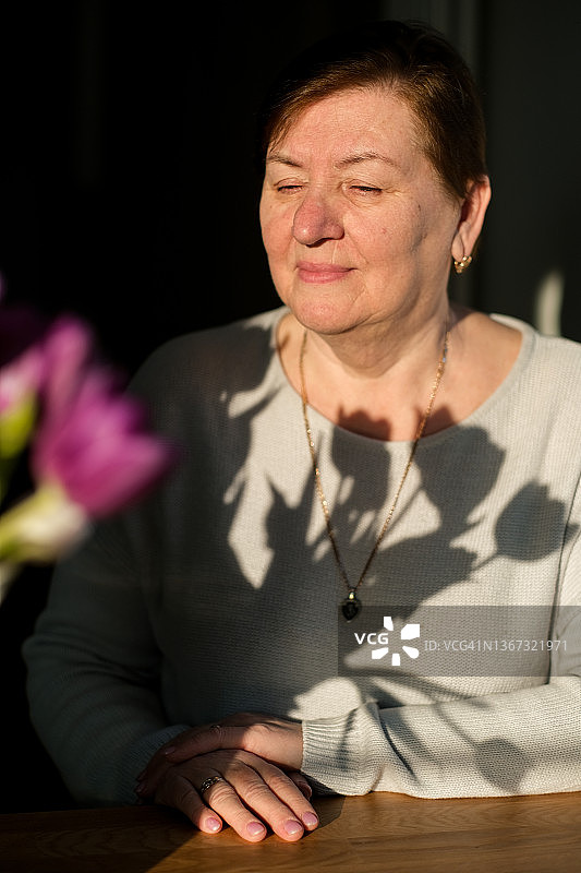 手捧郁金香的60岁以上女人肖像图片素材