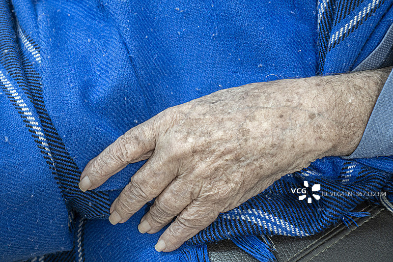 蓝色毯子上老人的手图片素材