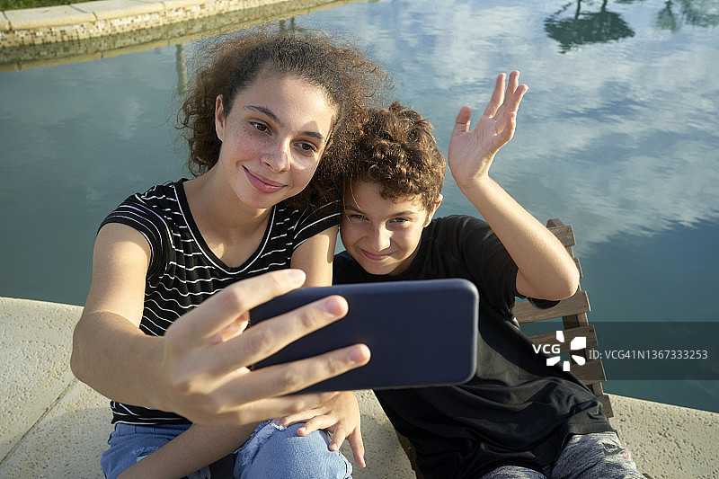 男孩和妹妹在泳池里自拍图片素材