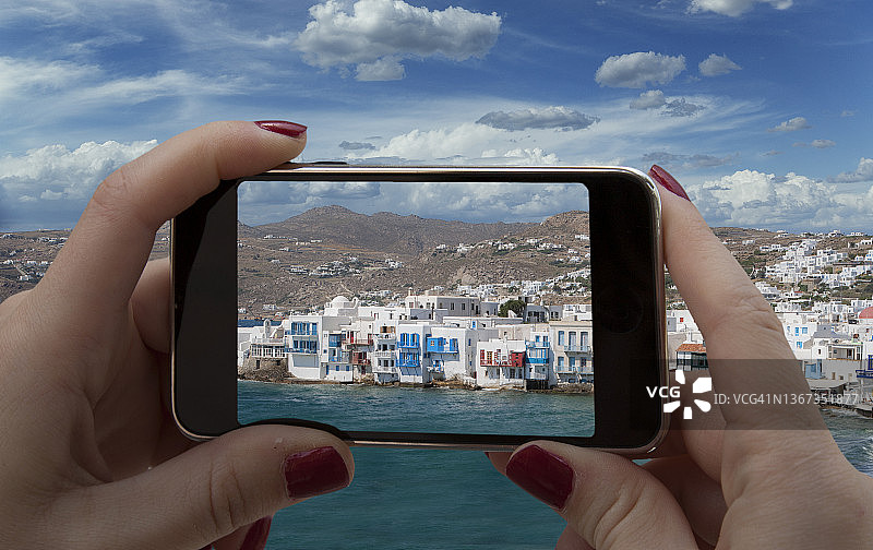 女子用智能手机拍摄米科诺斯岛图片素材