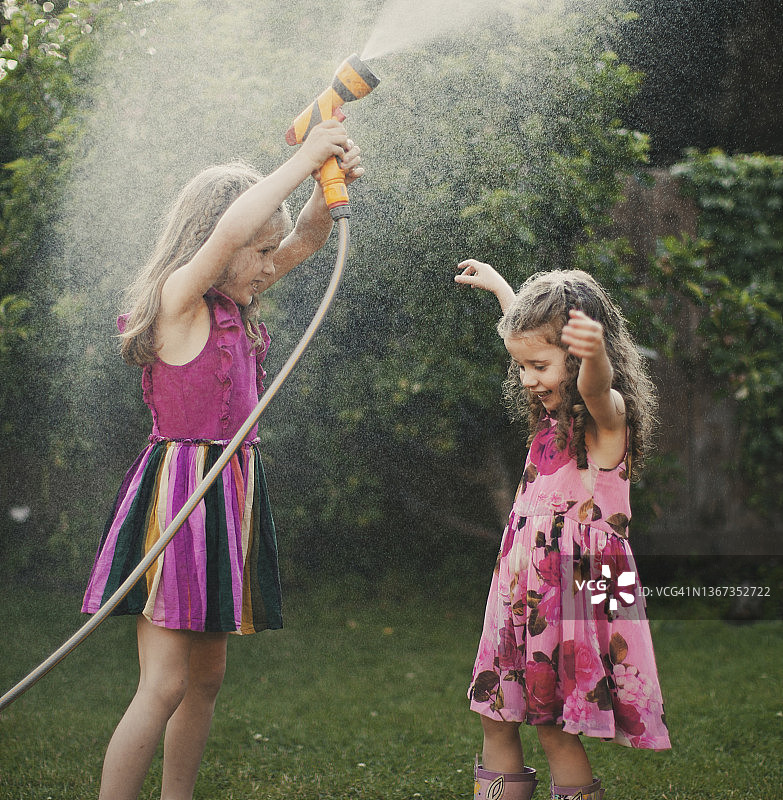 女孩玩花园软管图片素材