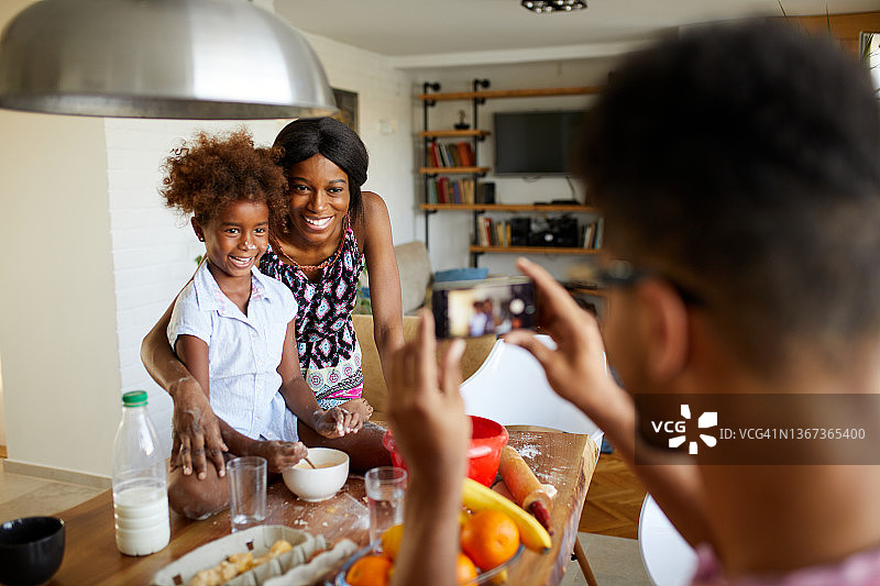 父亲给一家人做饼干拍照图片素材