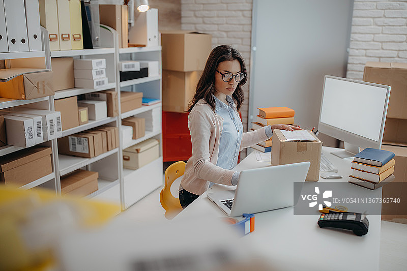 女人打包书籍准备送货图片素材