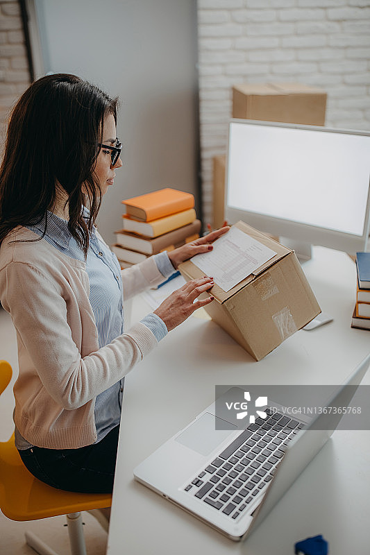 女人打包书籍准备送货图片素材