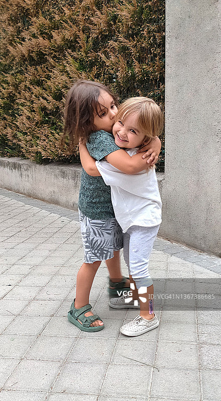 两个快乐的小伙伴在户外微笑拥抱图片素材