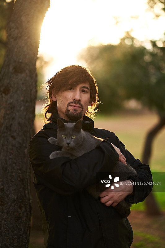 男子和他的猫站在一起图片素材
