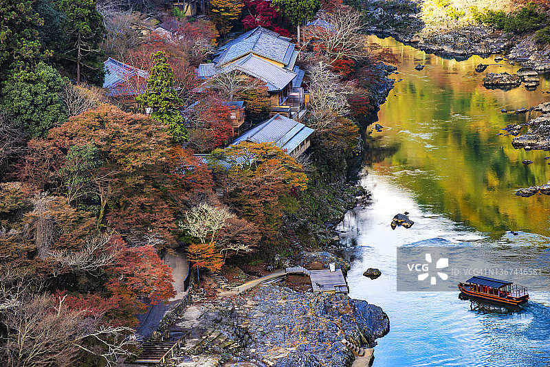 京都岚山保津川上山坡的彩色枫树与游船图片素材