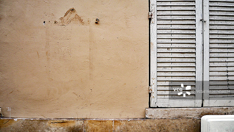 巴黎风化的棕色建筑立面和白色百叶窗图片素材