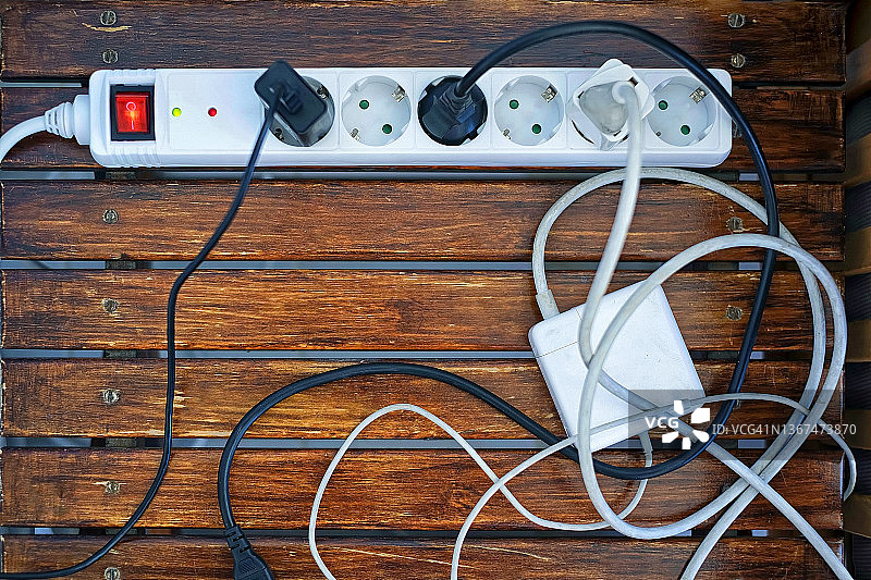 木桌上的白色电源插座和电线图片素材
