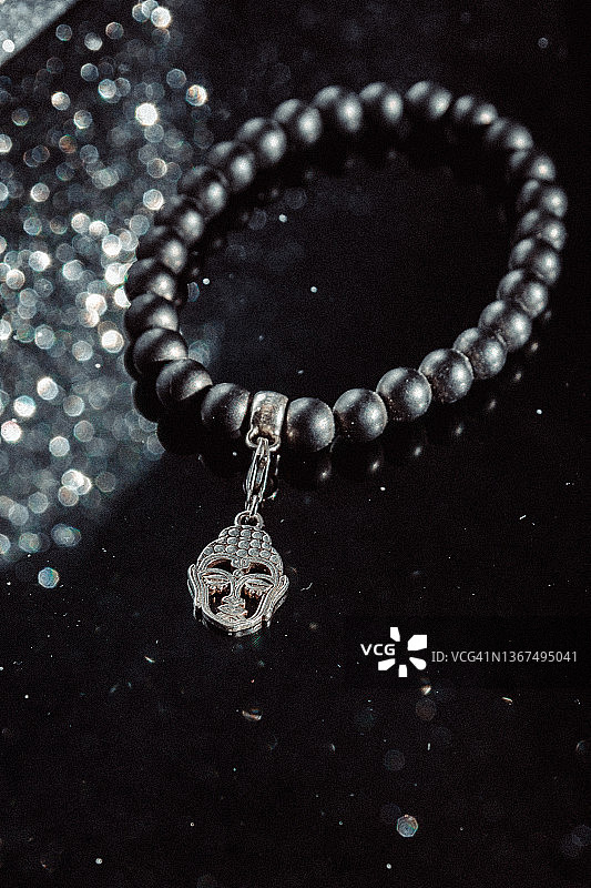 佛像吊坠手镯和闪光背景图片素材