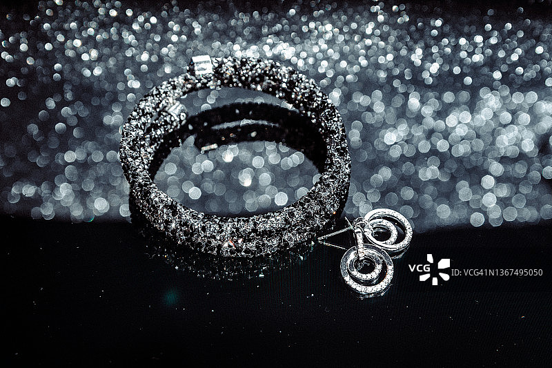 银色闪光背景下的手镯和耳环图片素材
