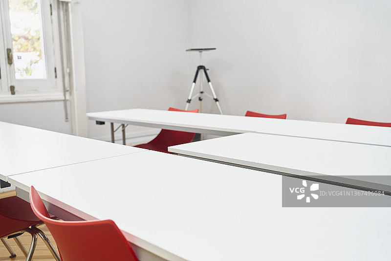 办公室会议室，配有白色墙壁、桌子和红色椅子图片素材