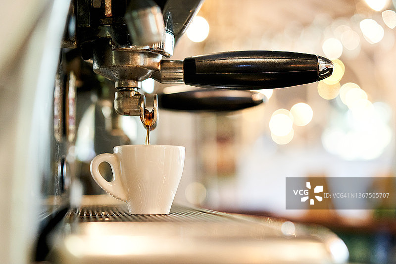咖啡机将咖啡滴入浓缩咖啡杯的特写图片素材