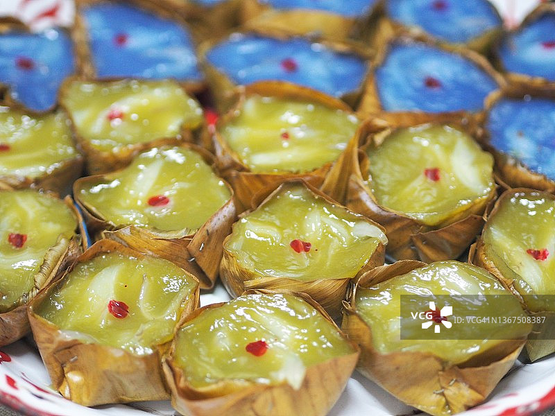 年糕金字塔甜点，糯米粉和糖制成，用香蕉叶小篮盛放，不锈钢托盘蒸熟图片素材