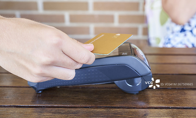 女人用数据电话进行银行卡支付图片素材