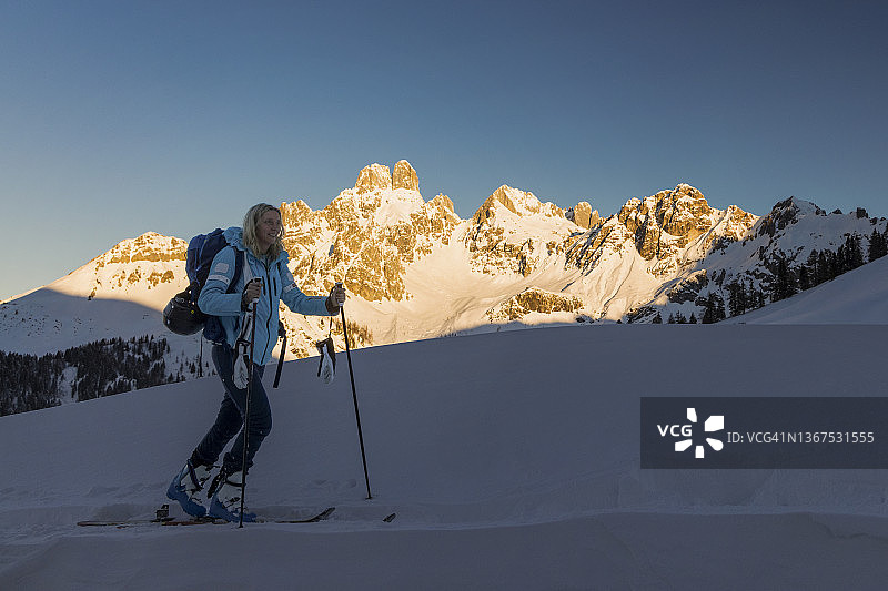 滑雪旅行-年轻的女子在前往达赫斯坦山的山顶前的高山牧场的路上图片素材