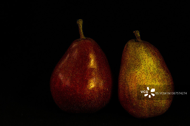黑色背景上的两个成熟梨子图片素材