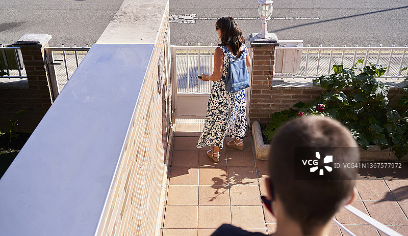 母亲和儿子走出房屋的俯视图图片素材