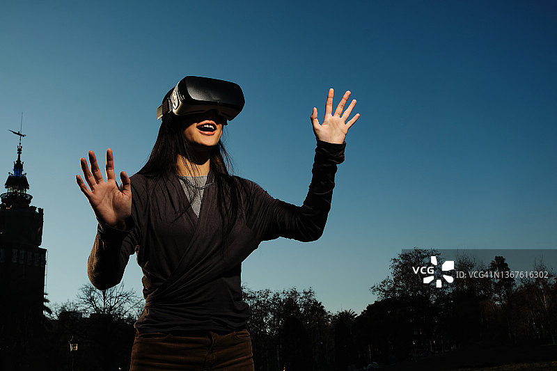 年轻的亚洲女性在户外佩戴VR头显图片素材