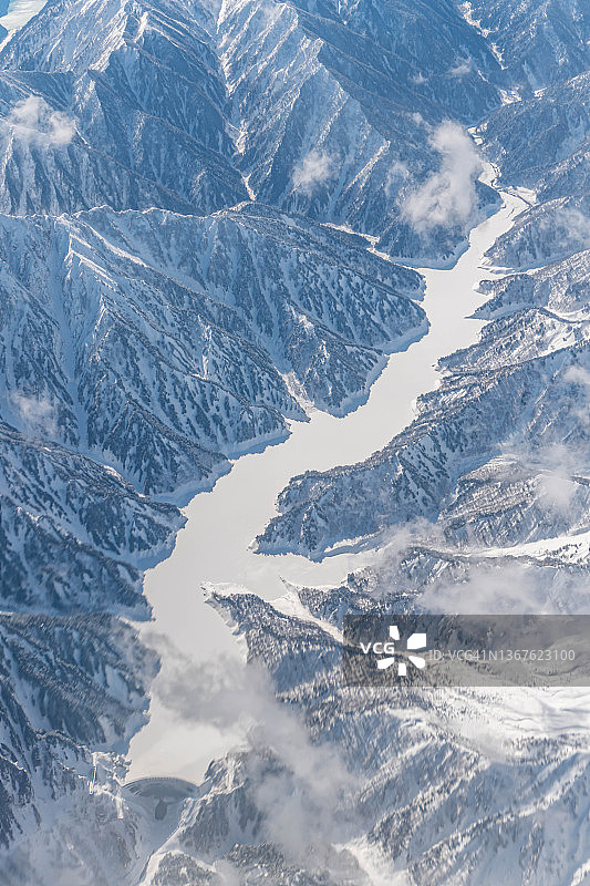 从飞机上俯瞰日本富山雪山间的冰冻湖面图片素材