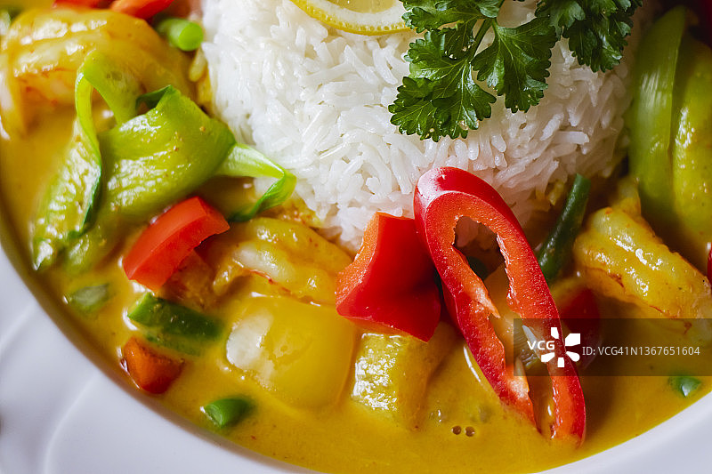 餐厅白盘盛放的新鲜蔬菜咖喱虾特写顶视图图片素材