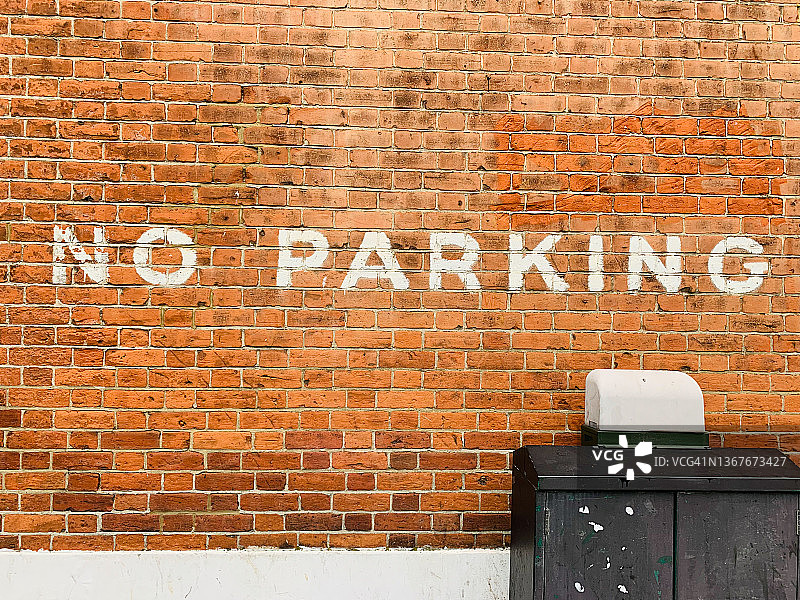 红色砖墙上的禁止停车图片素材