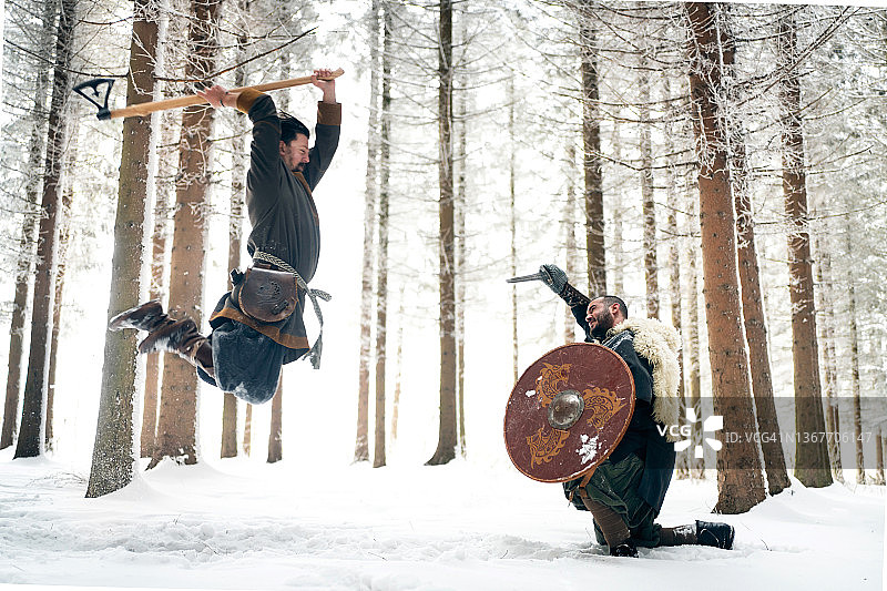 冬季森林中，中世纪武士持斧攻击图片素材