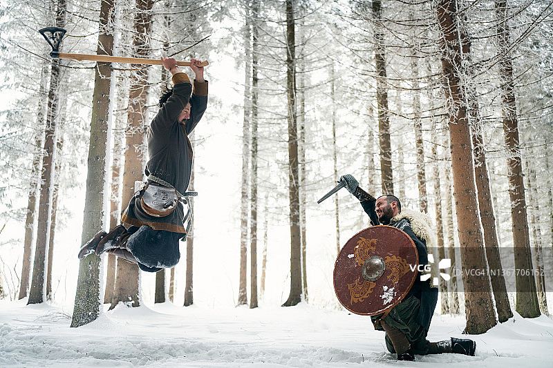 冬季森林中，中世纪武士持斧攻击图片素材