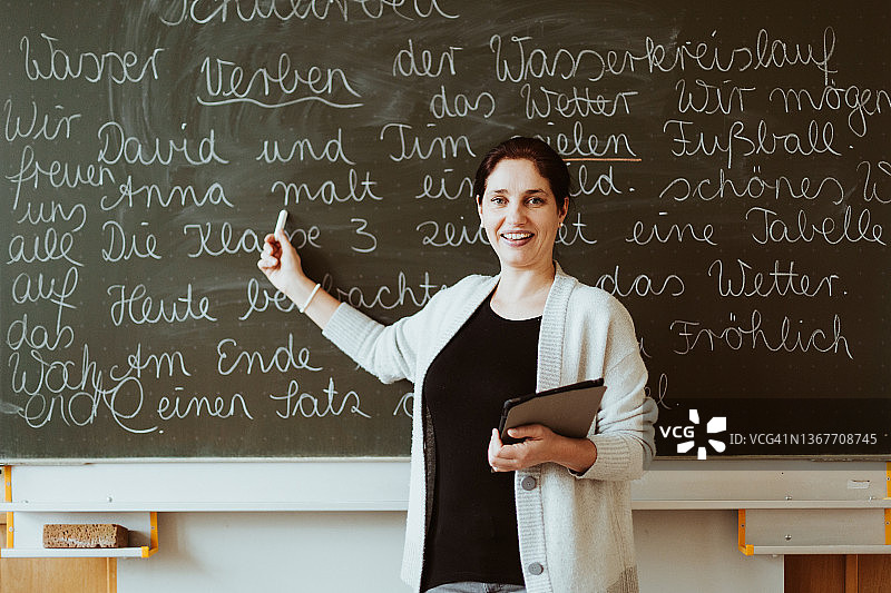 女老师指着写满字的黑板授课图片素材