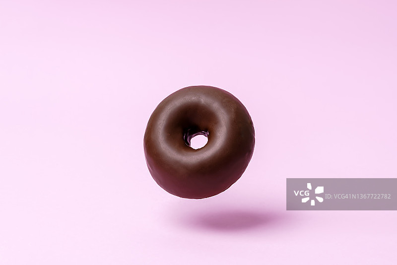 粉色背景上的巧克力甜甜圈图片素材
