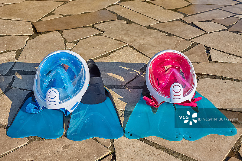 粉色和蓝色潜水面罩放在脚蹼上图片素材