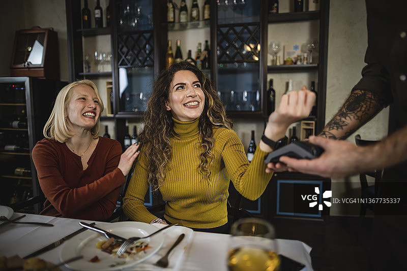 朋友们在餐厅非接触式支付图片素材