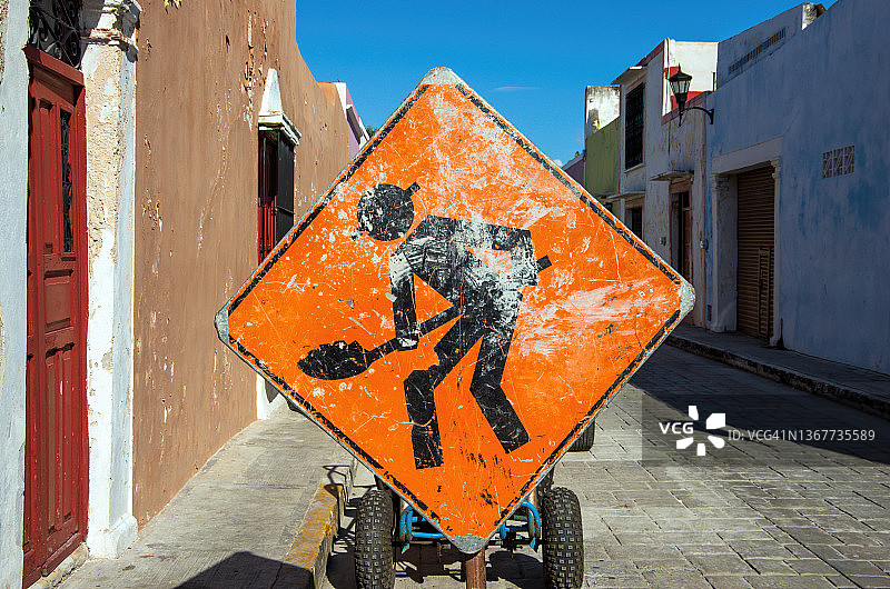 狭窄街道上的前方施工交通警告标志图片素材