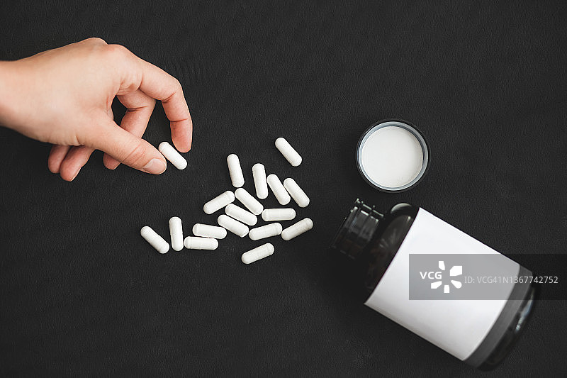 女子服用维生素和补充剂图片素材