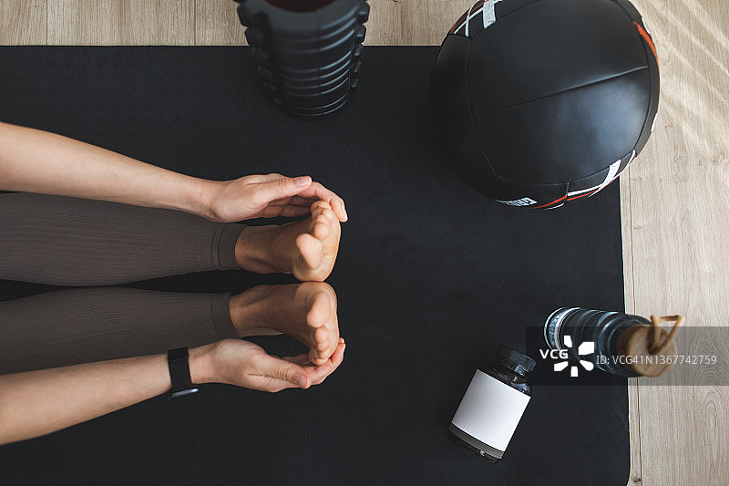 年轻女子在室内垫子上做瑜伽伸展运动图片素材