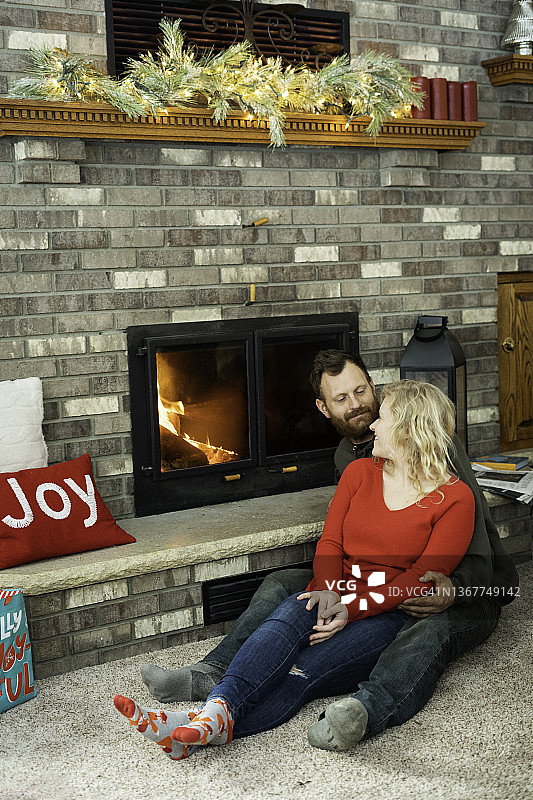 情侣在温暖的炉火旁依偎图片素材