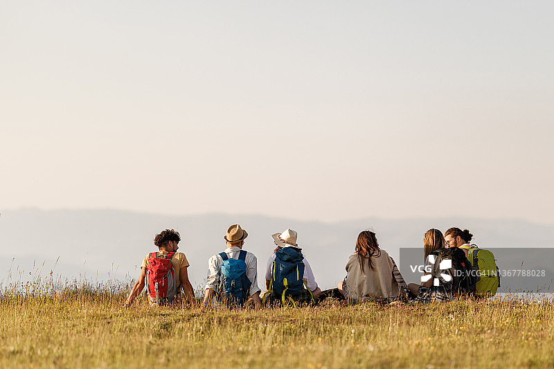 徒步旅行者在山丘上休息的背影图片素材