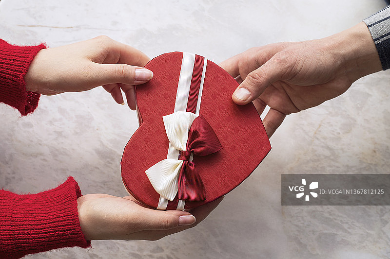 情人节概念：相爱男女在咖啡馆互赠礼物图片素材