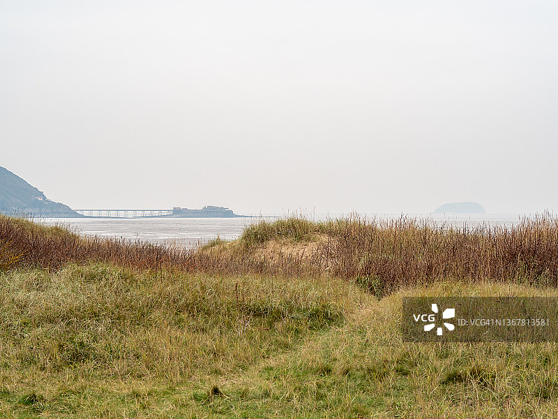 覆盖着草的沙丘和旧码头图片素材