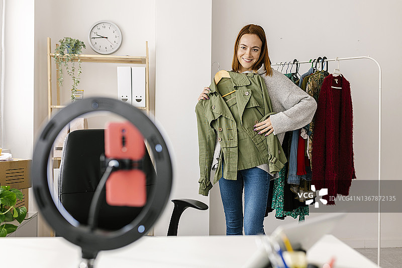 年轻女网红在家拍摄新潮服装视频图片素材